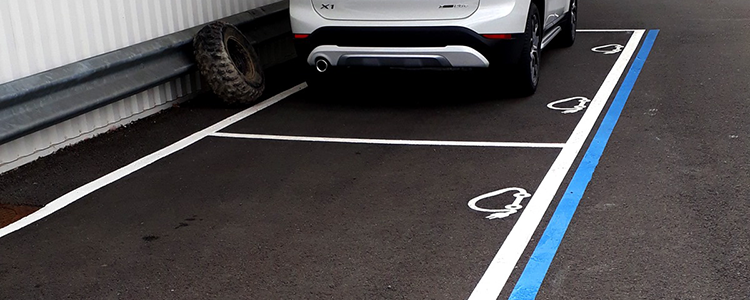 Réalisation du marquage au sol des places de parking réservées au voitures électriques chez BMW.